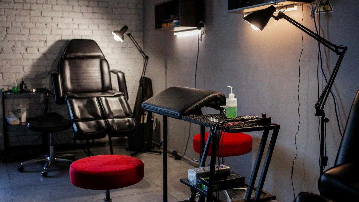 Illustrated tattoo studio interior with artwork and artist workspace
